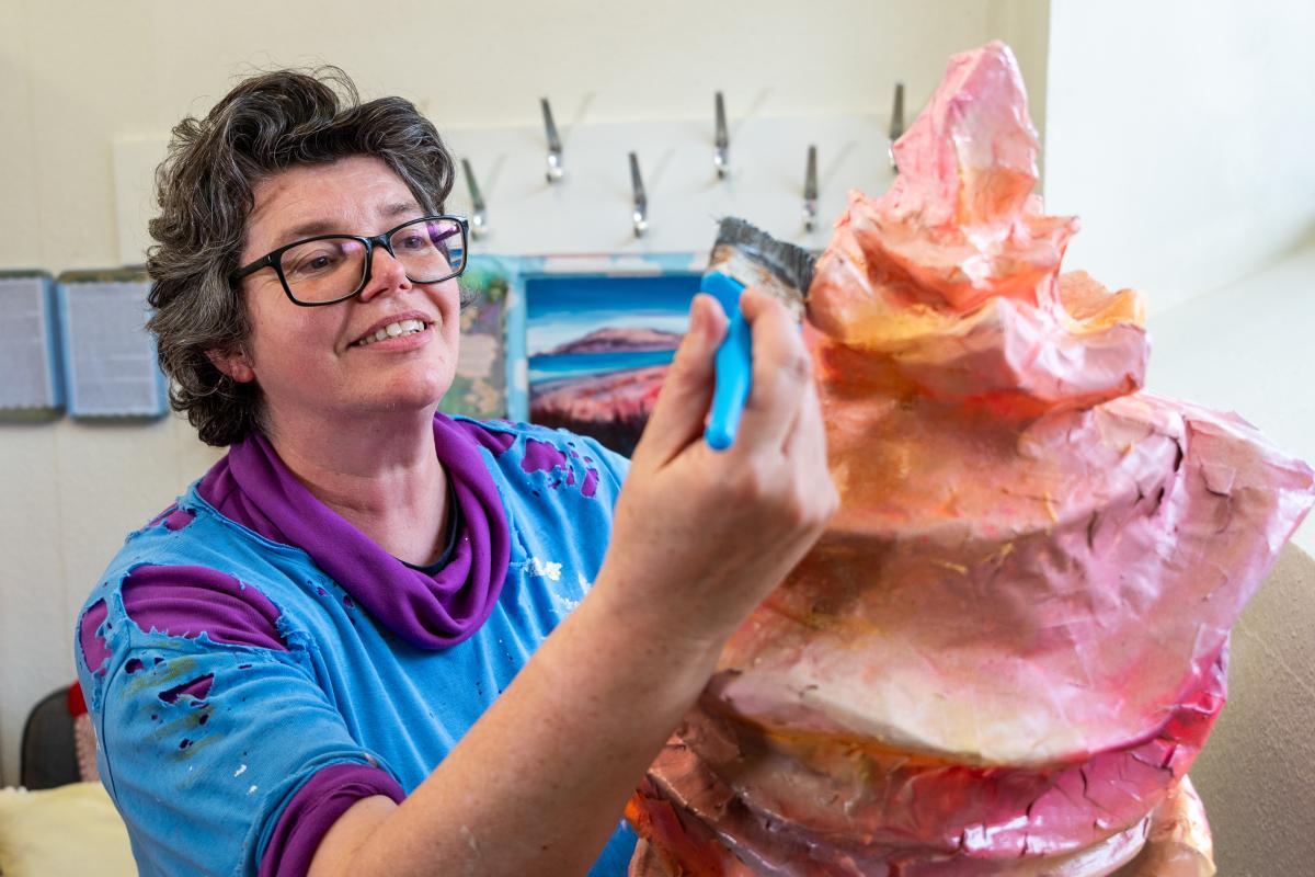 A lady painting a sculpture 