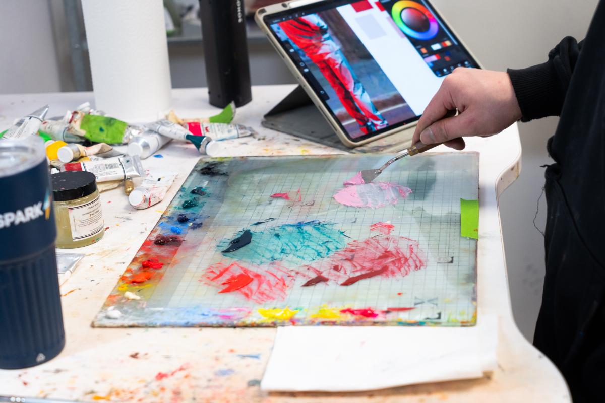 Paints being mixed with a pallete knife